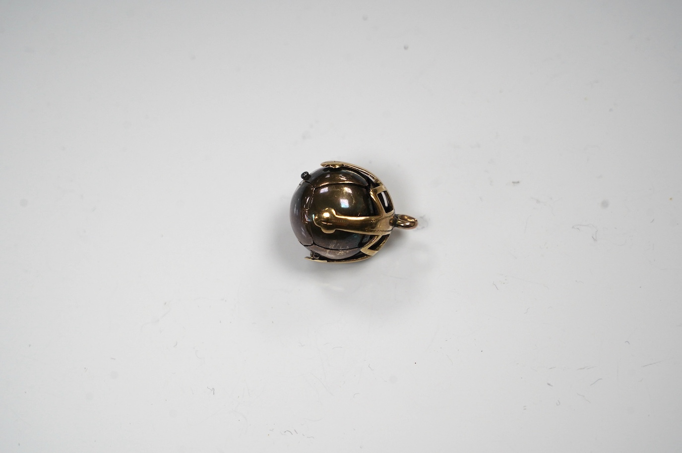 A yellow metal and white metal masonic ball pendant, the yellow metal stamped 9ct, 17mm. Condition - fair